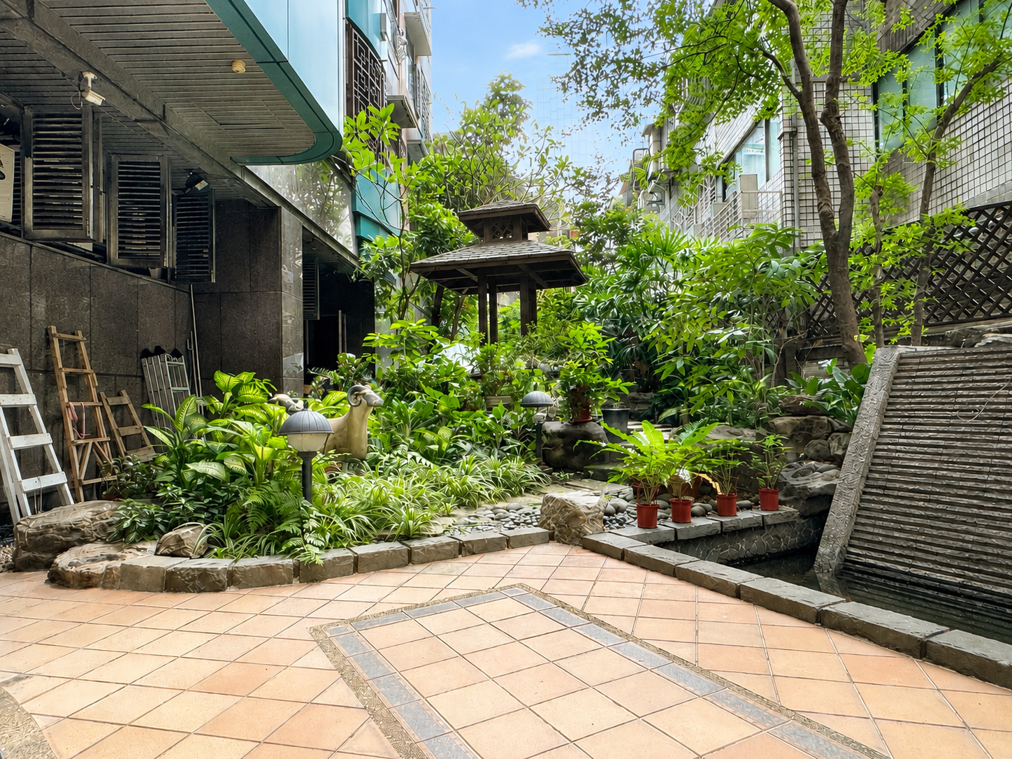 逸仙雅仕一樓公共花園，植栽、水景與小亭形成社區戶外綠意角落。The rooftop shared area supports laundry and drying needs, with washing machines, dryers, counters, and drying racks visible in the space.三樓健身房Third-Floor Gym健身房內可見跑步機、健身車與簡易運動設備，方便住戶在社區內完成日常運動。